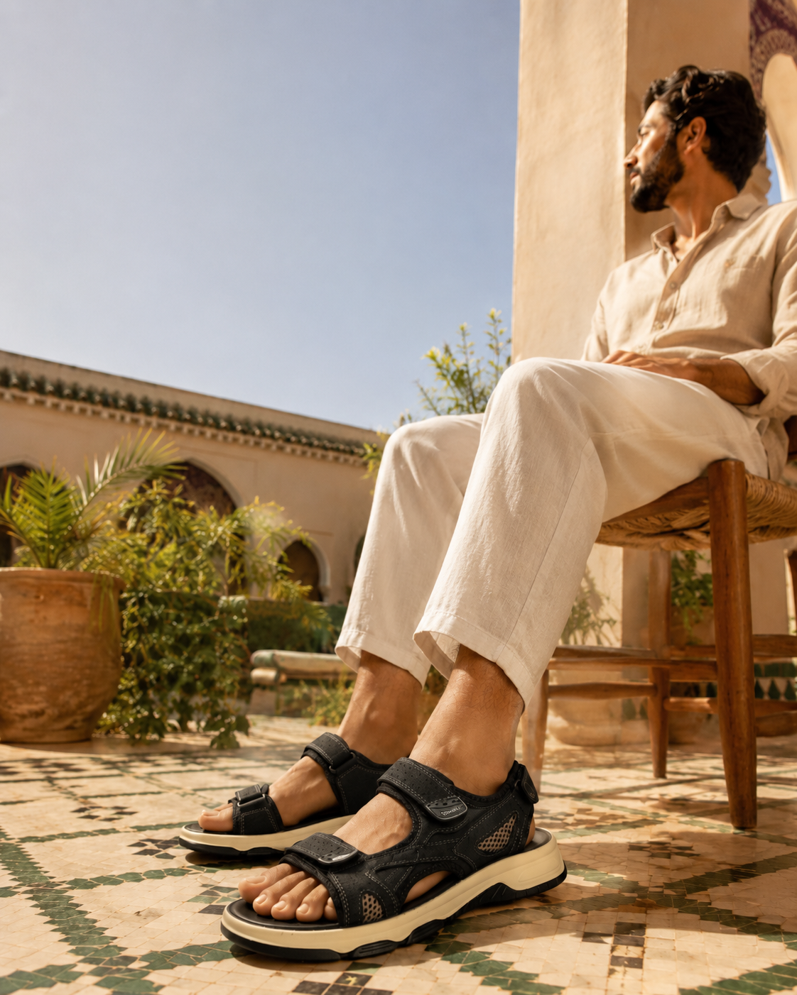 Homme portant une sandale RamiWear noire dans un riad marocain